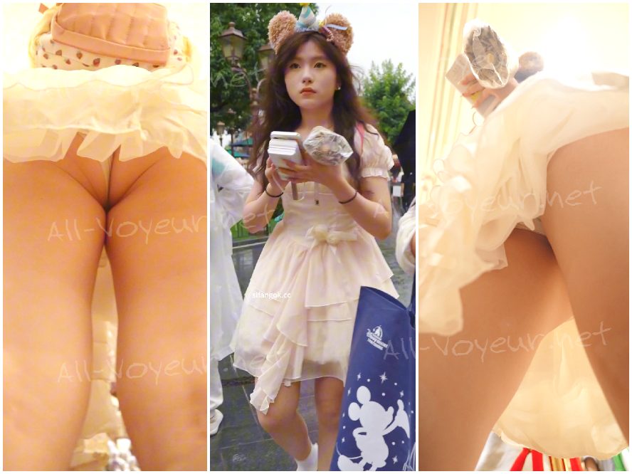 青いレースのドレスを着た若い女性がパフォーマンスを見ています...彼女は半透明のアンダーシャツを着て半分しゃがんでおり、CDをかけています。