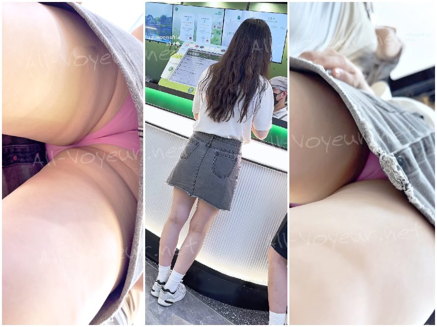 短いスカートをはいた若い女性が、脚の間にカメラとCDプレーヤーを挟み、前かがみになって、ピンクの縫い目のないパンティーを露わにしている。