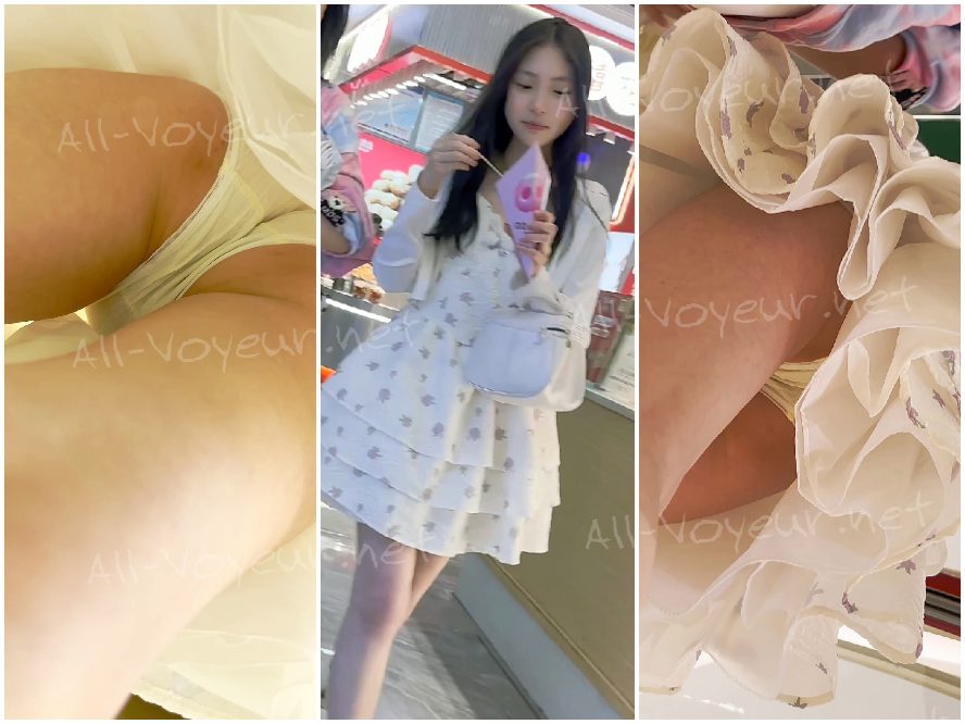 母親と幼い弟と一緒に買い物に出かけている若い学生。彼女は透け感のある赤いロングドレスを身にまとっており、その下には白い使い捨ての下着が透けて見えている。