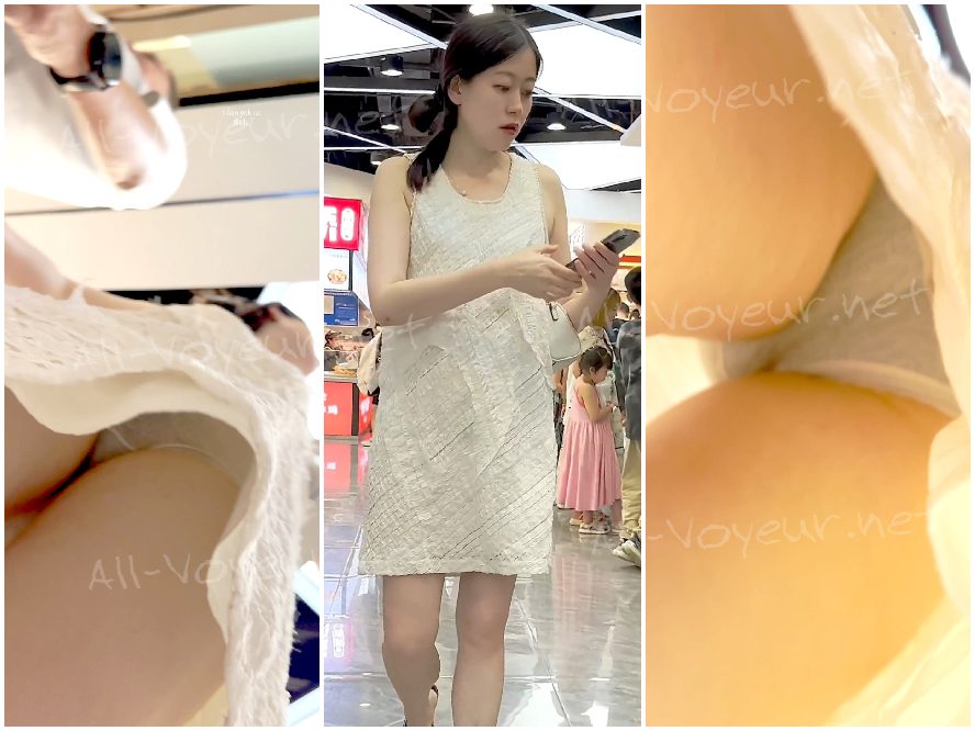 長いドレスを着た若い女性。白い半透明の下着から大きな臀部が露わになり、前身頃は濃い色の塗料で覆われている。